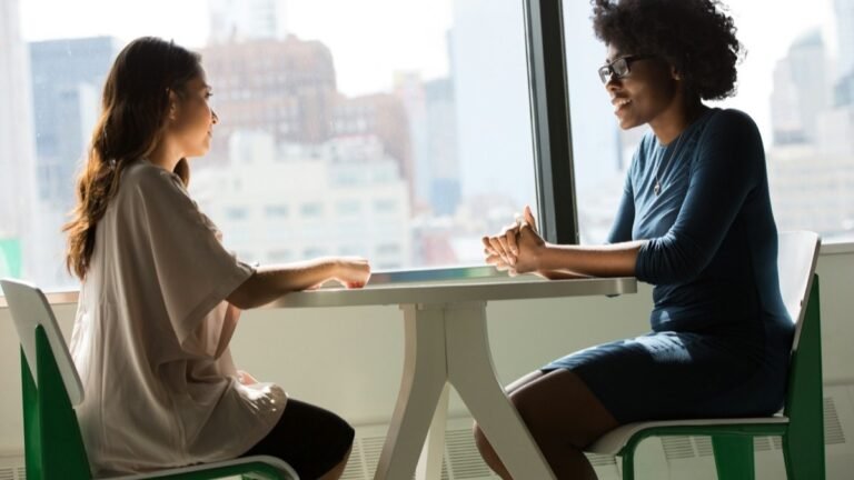 Two professionals talking across a table