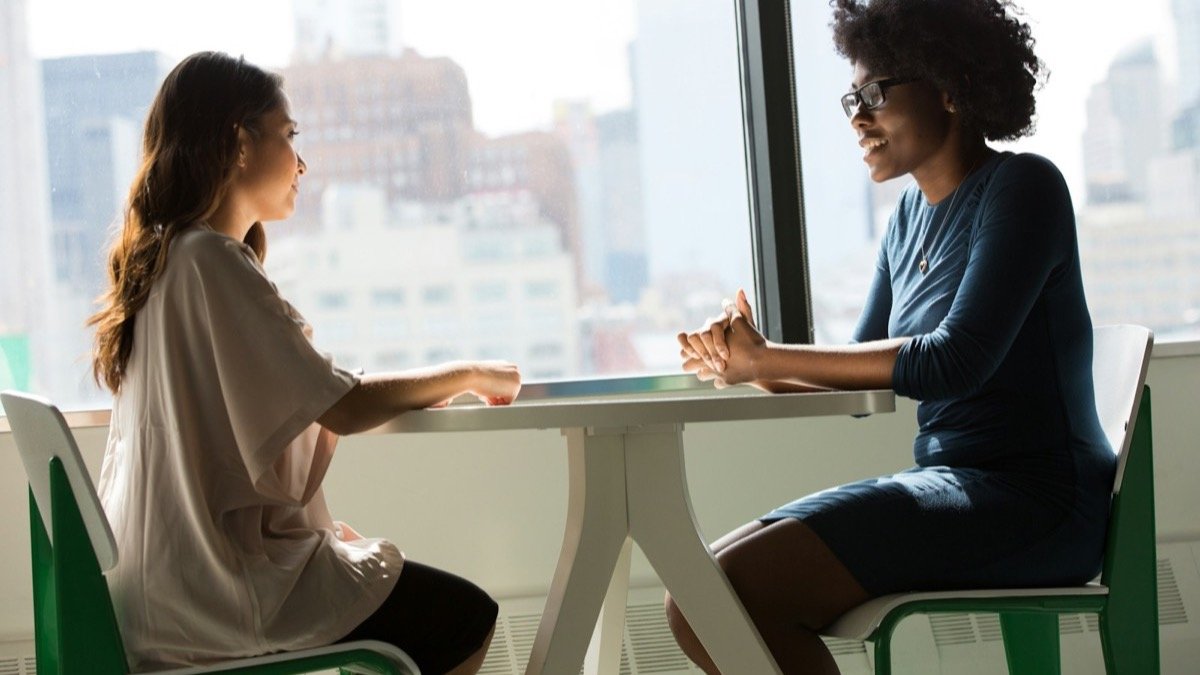 Two professionals talking across a table