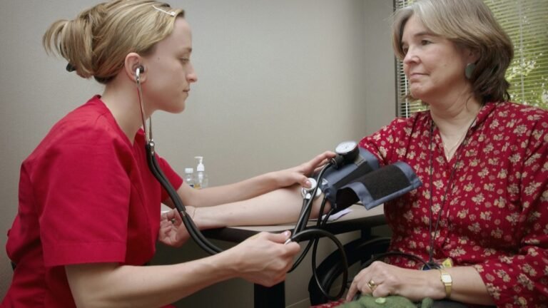 Clinician measuring a seated patient's blood pressure