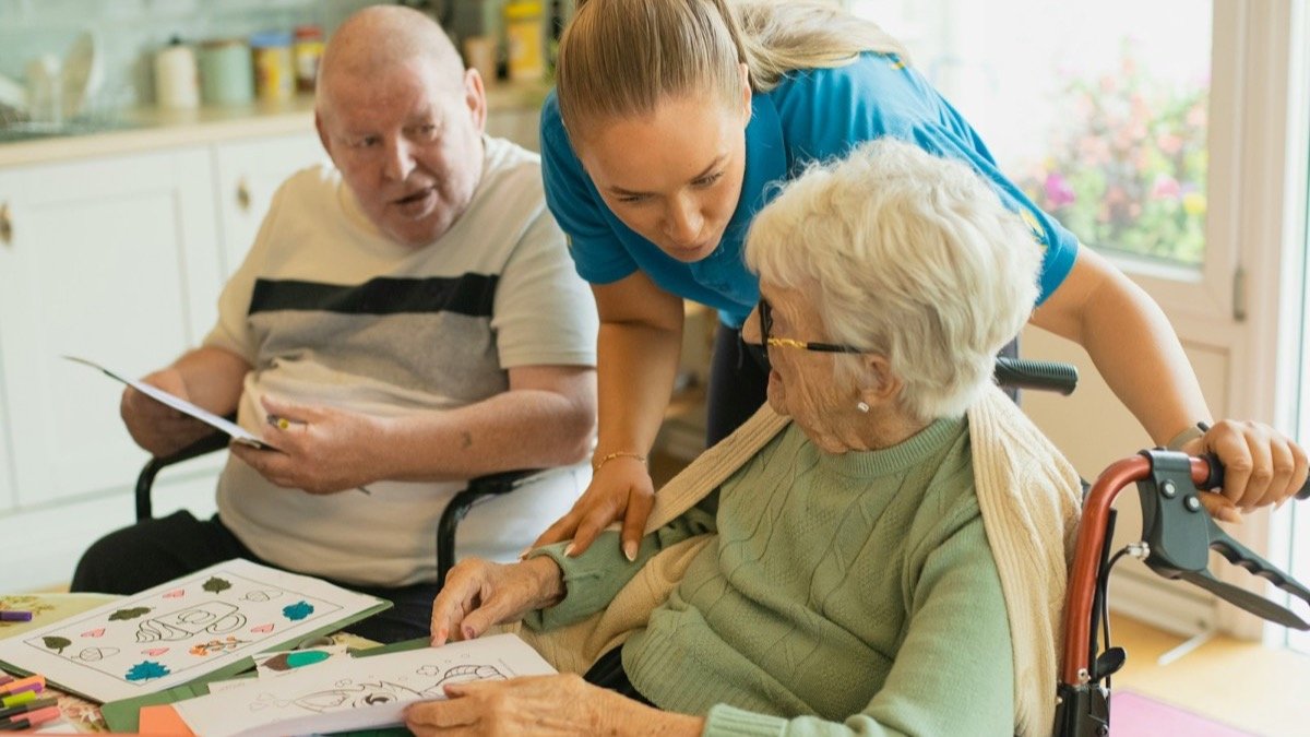 Caregiver assisting elderly residents with an activity